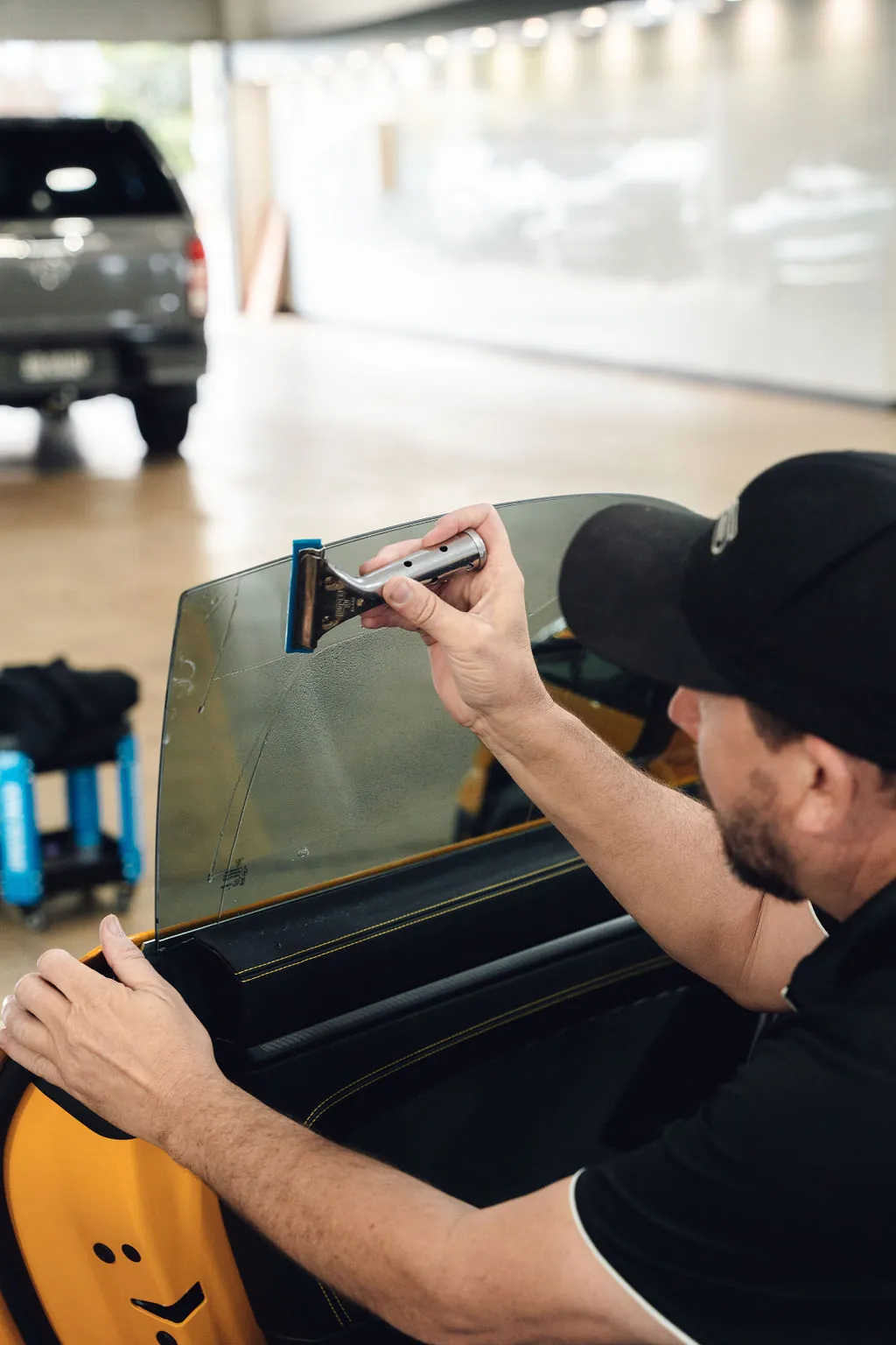 Installer squeegeeing window tint on a door glass